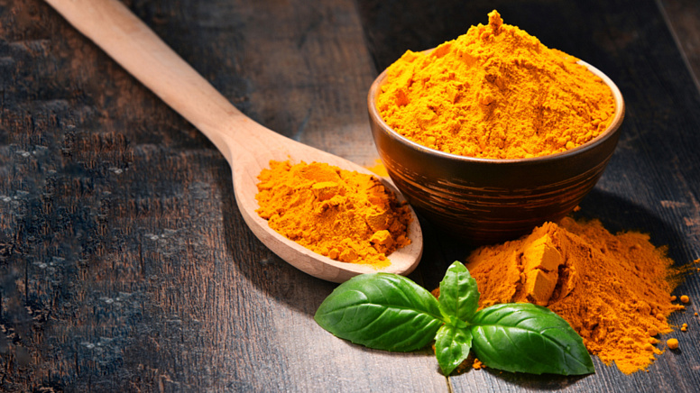 Turmeric, a pot with turmeric, a spoon with turmeric